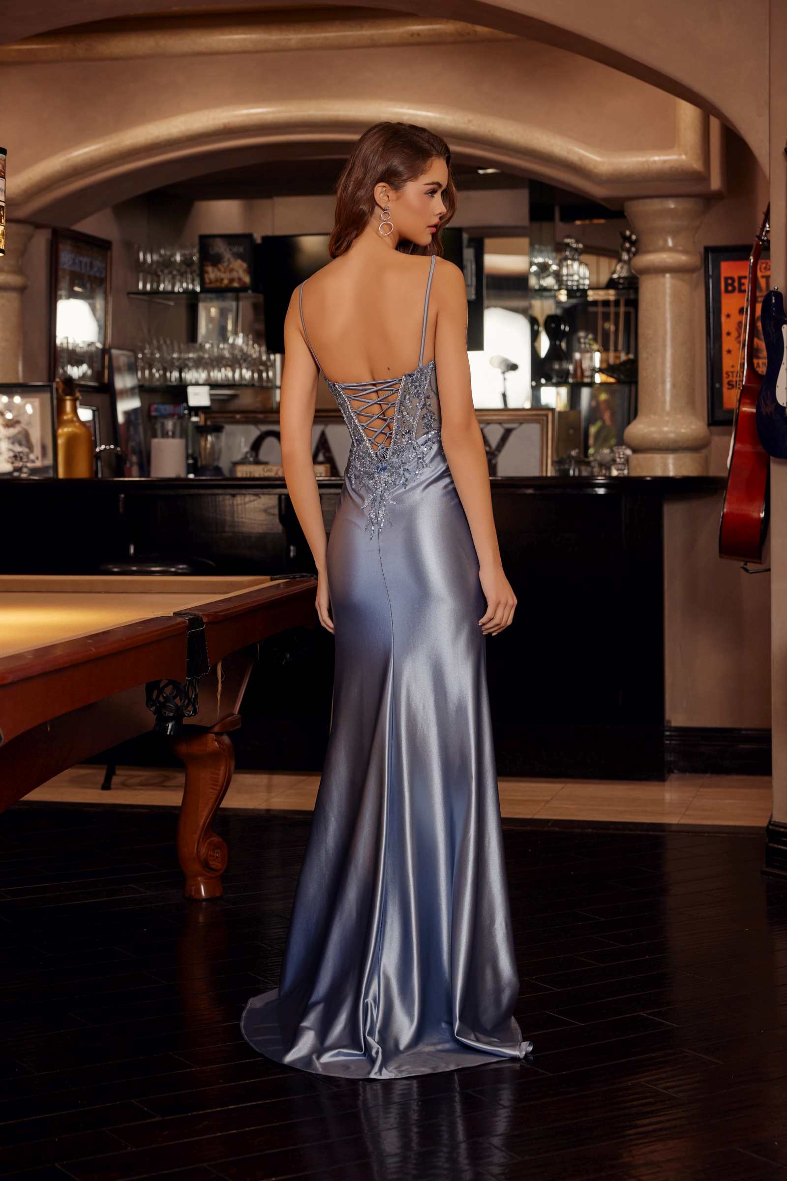 Smoky blue shiny satin prom gown back view with open-back straps and long flowing skirt