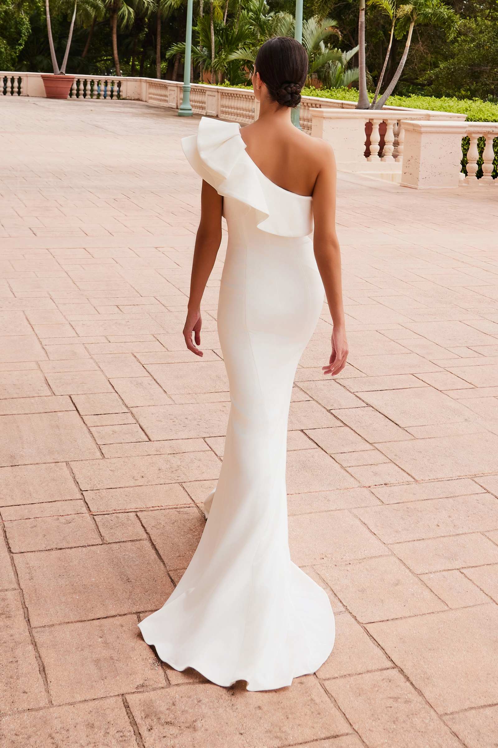 White one-shoulder ruffle back overlay sheath gown with long train and side slit