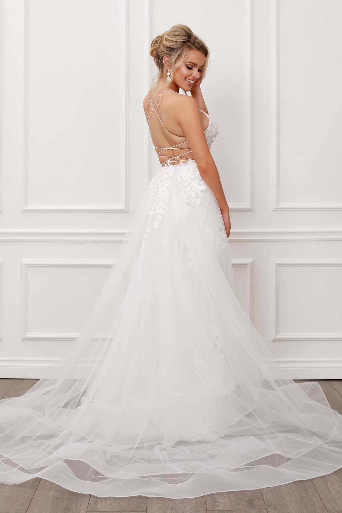 Light mermaid gown with lace applique, open back, and flowing sheer tulle train