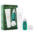 Skin care trio set with green serum dropper, cleanser tubes, and cream jar