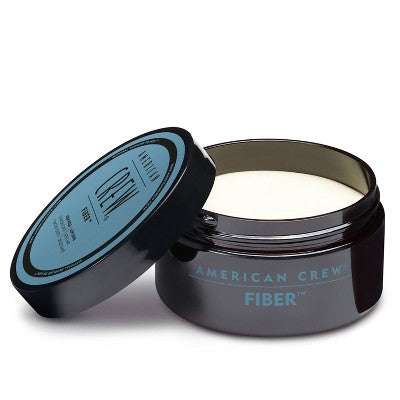 Hair fiber jar with lid open, dark container with blue American Crew Fiber label