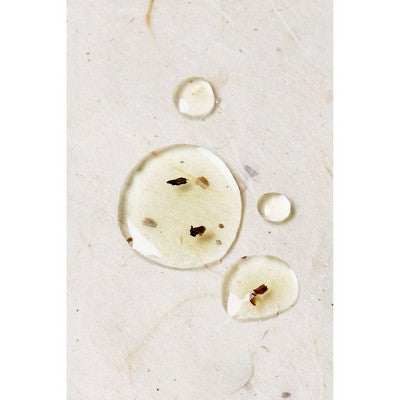 Hair and scalp oil drops and small ring pieces on a light surface