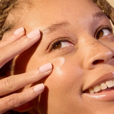 Eye balm applied under eye with fingertips
