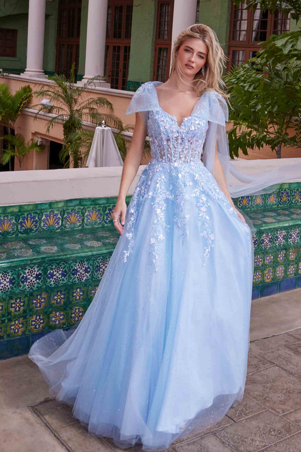 Light blue tulle dress with sequined bodice, draped tie-up straps, and flared skirt