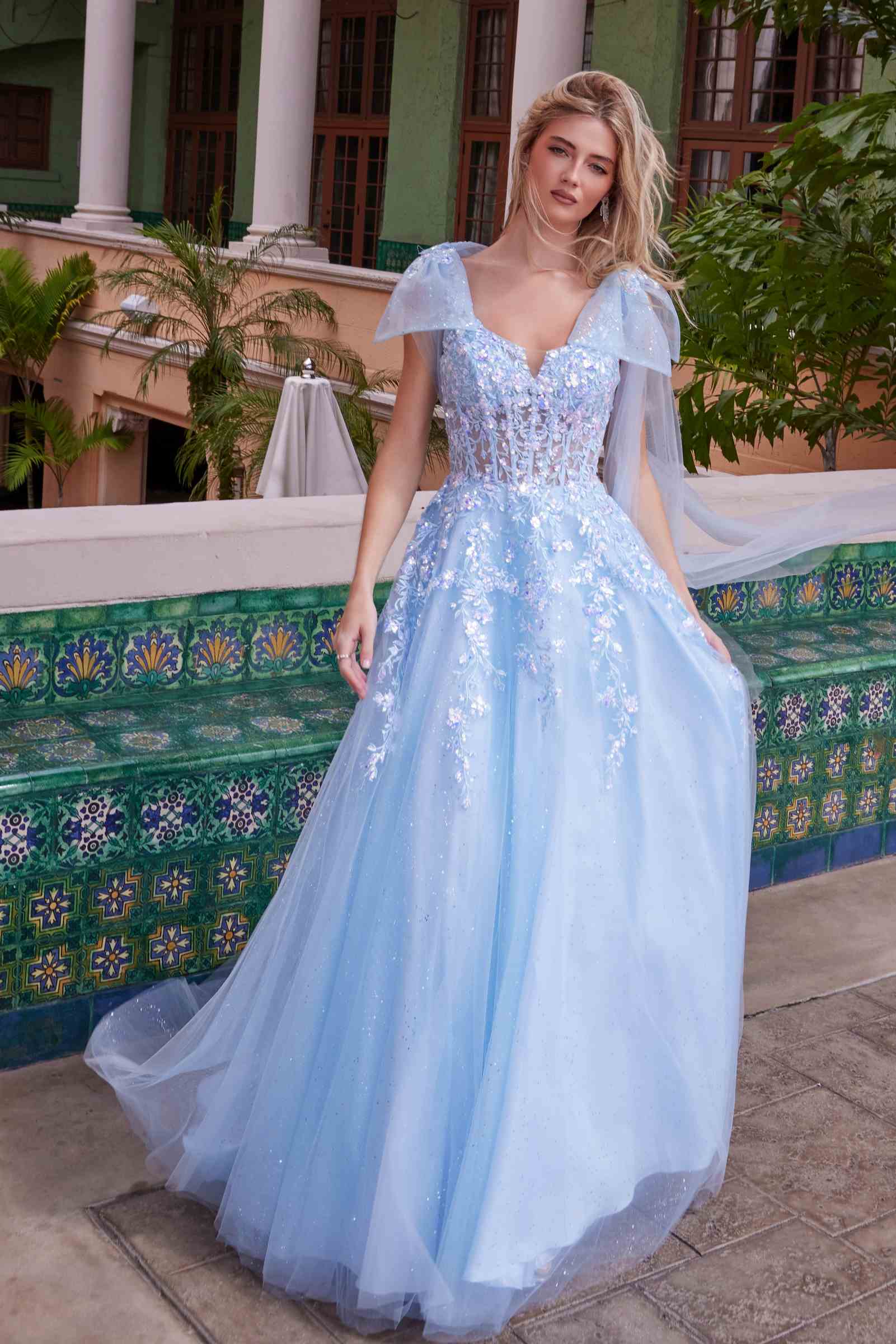 Light blue tulle dress with sequined bodice, draped tie-up straps, and flared skirt