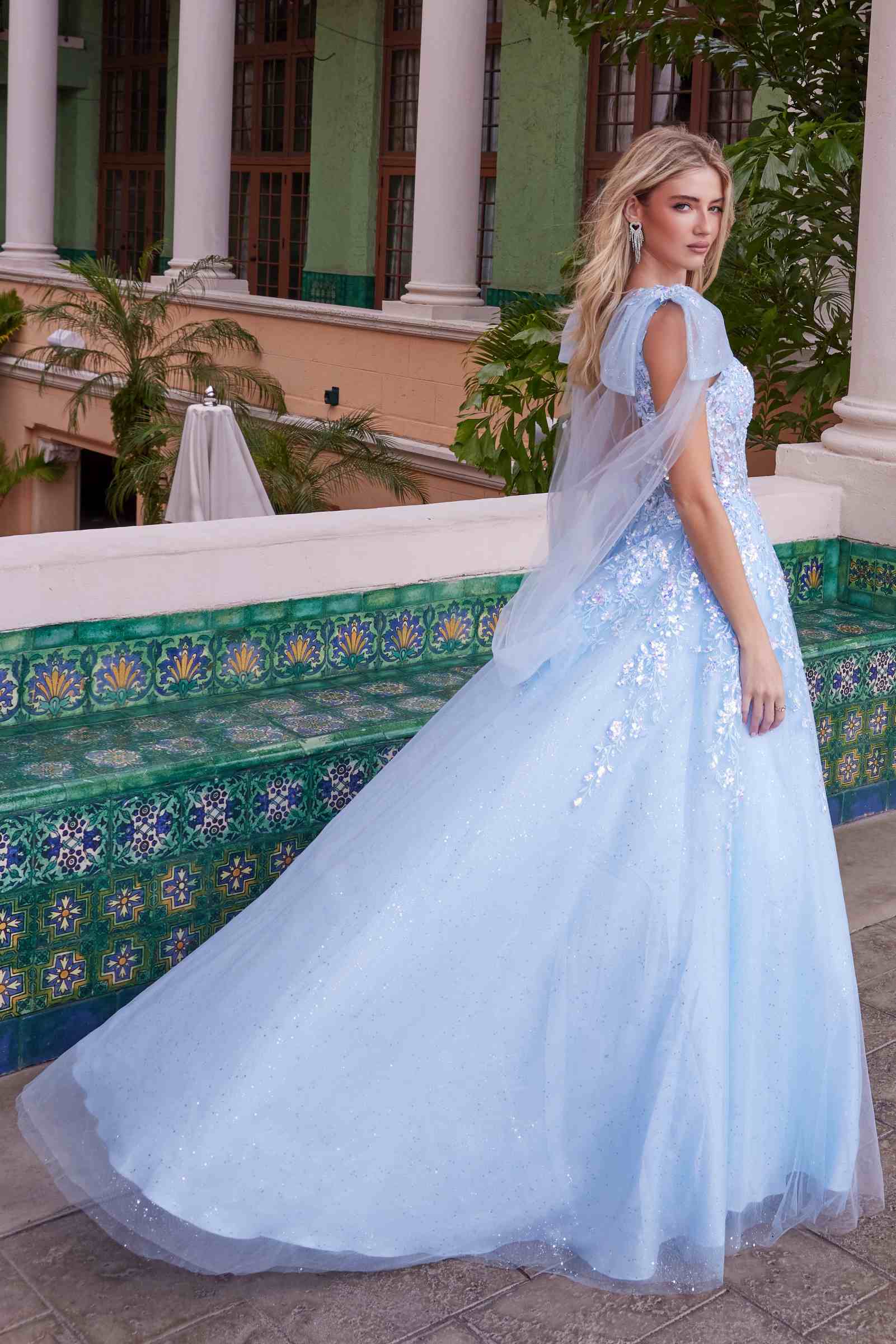 Light blue tulle dress with draped tie-up straps and appliqué bodice, flowing skirt