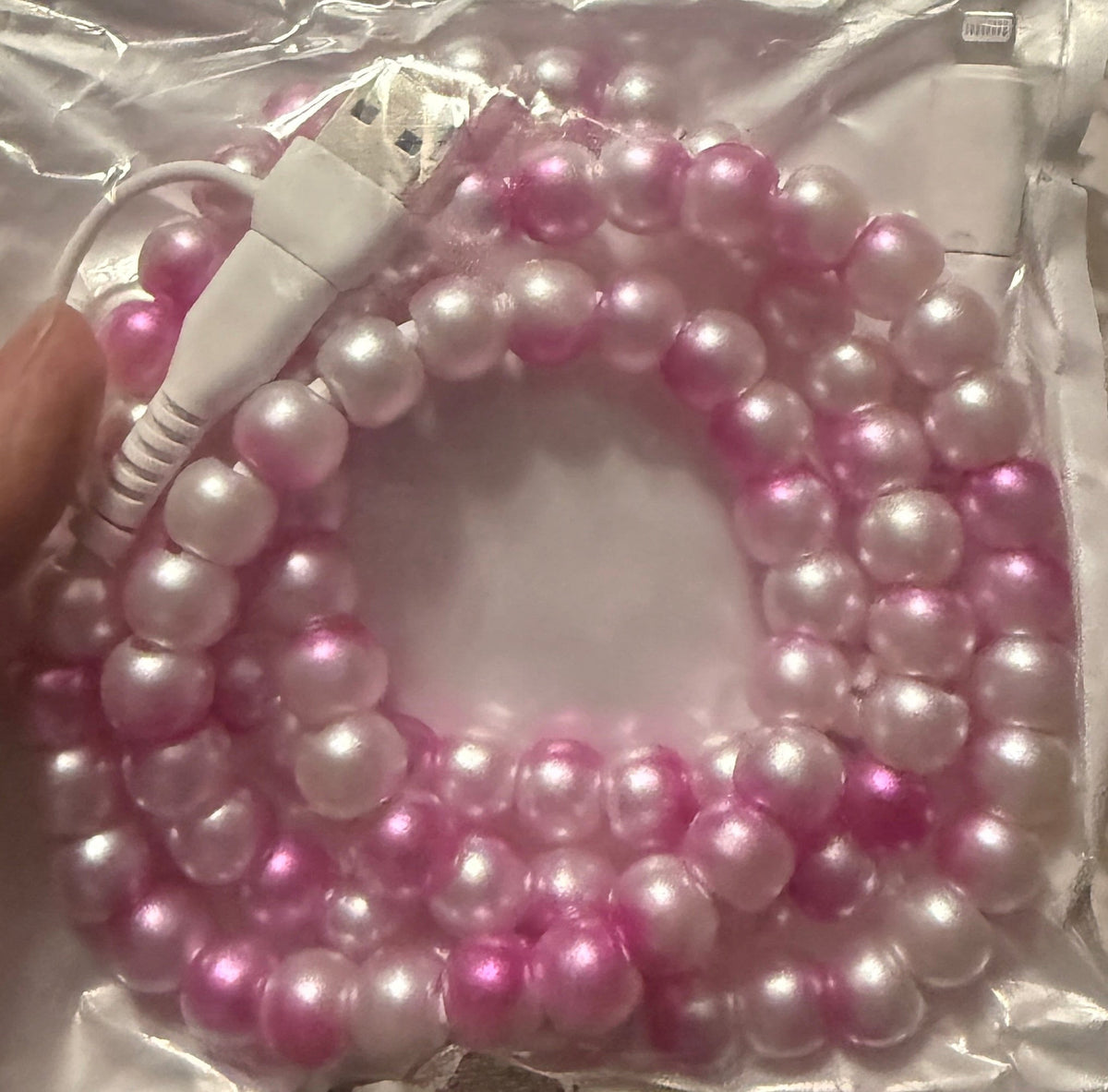 Beaded 4-in-1 charging cable with iridescent pink and white beads, dual connectors visible