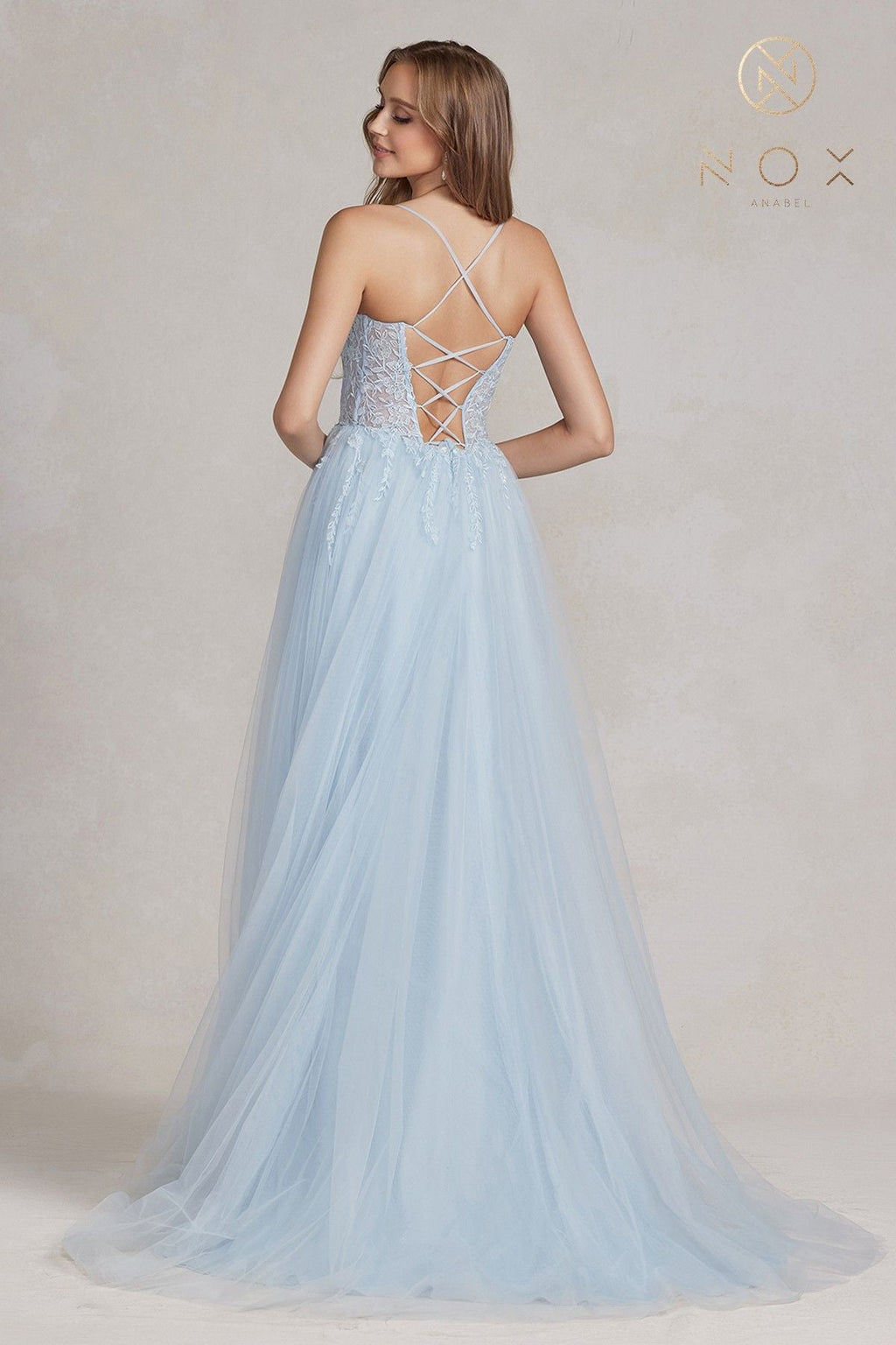 Light blue A-line tulle gown with crisscross back straps and full flowing skirt