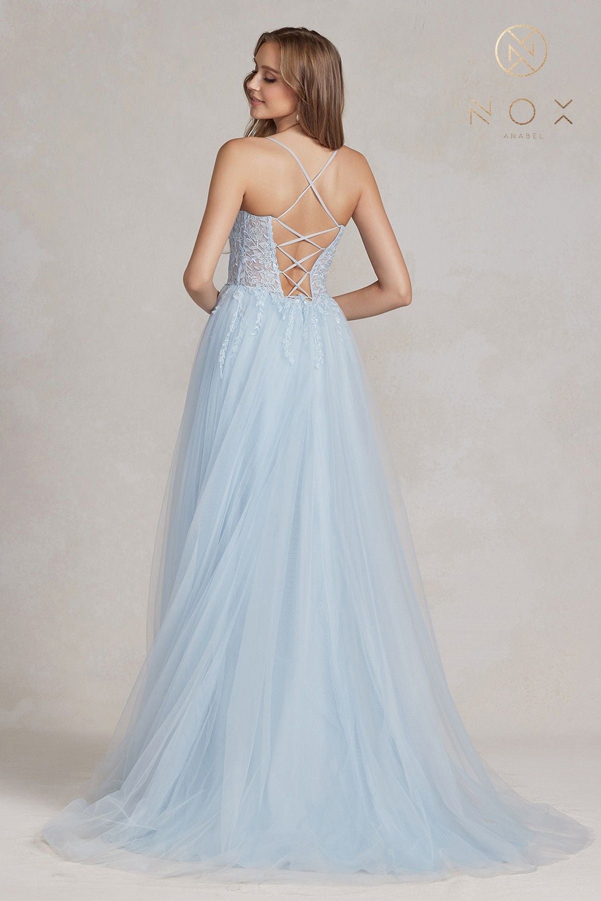 Light blue A-line tulle gown with crisscross back straps and full flowing skirt
