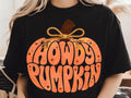 Black pumpkin graphic tee with orange Howdy Pumpkin lettering and bow