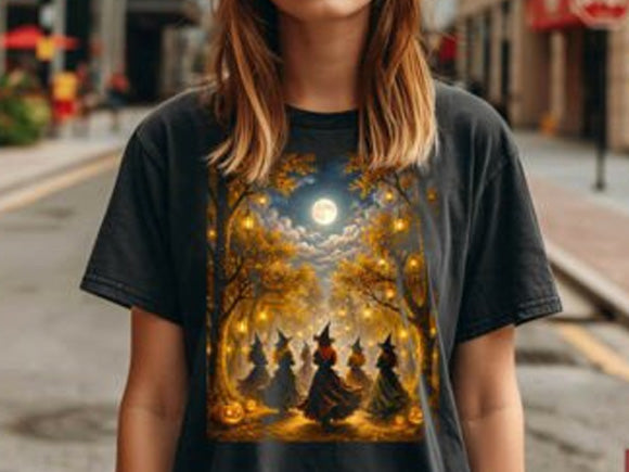 Dark graphic tee with moonlit witches under a glowing autumn forest