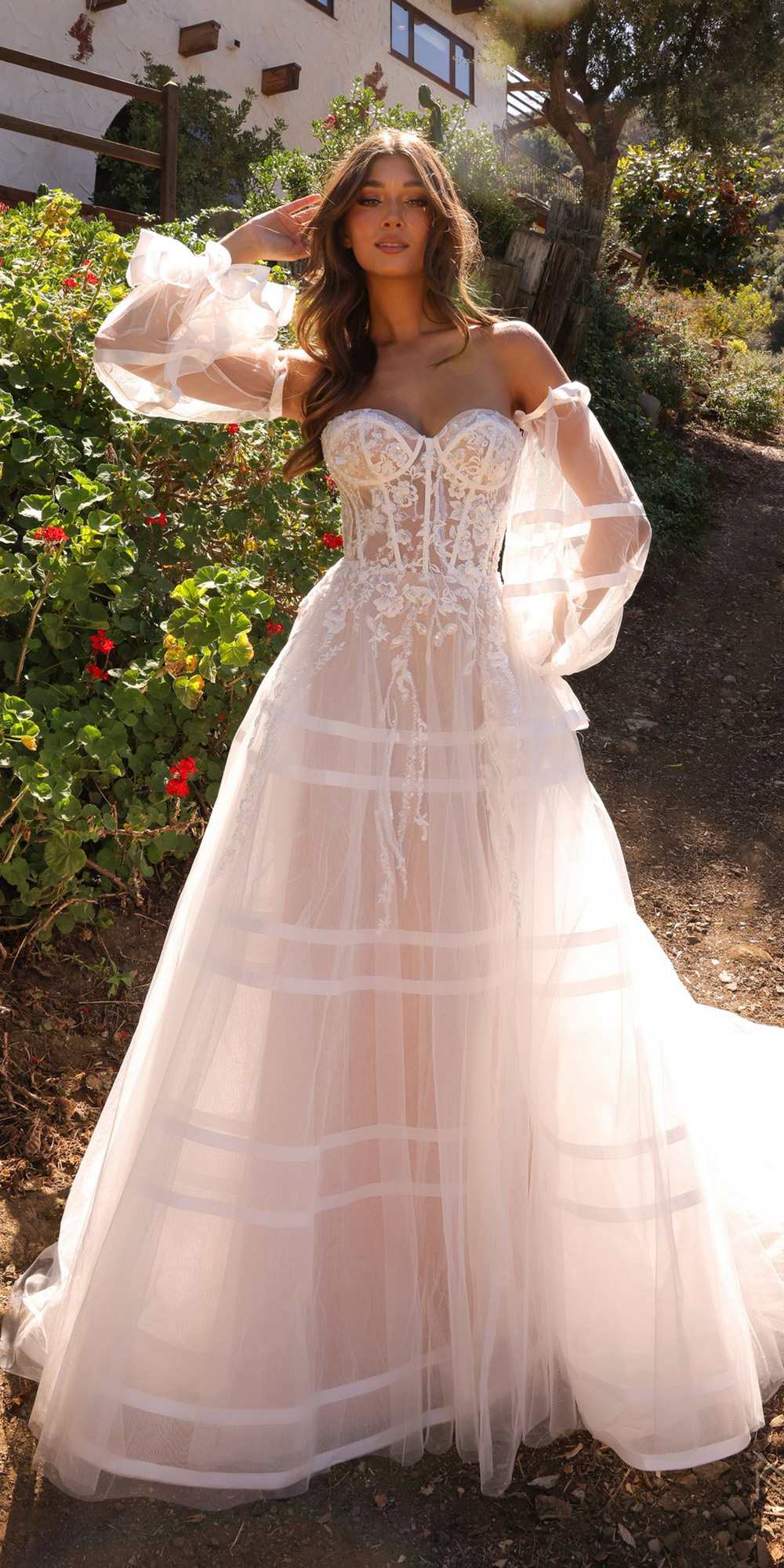 White strapless corset bridal gown with sweetheart bodice, long sheer puff sleeves, layered A-line skirt
