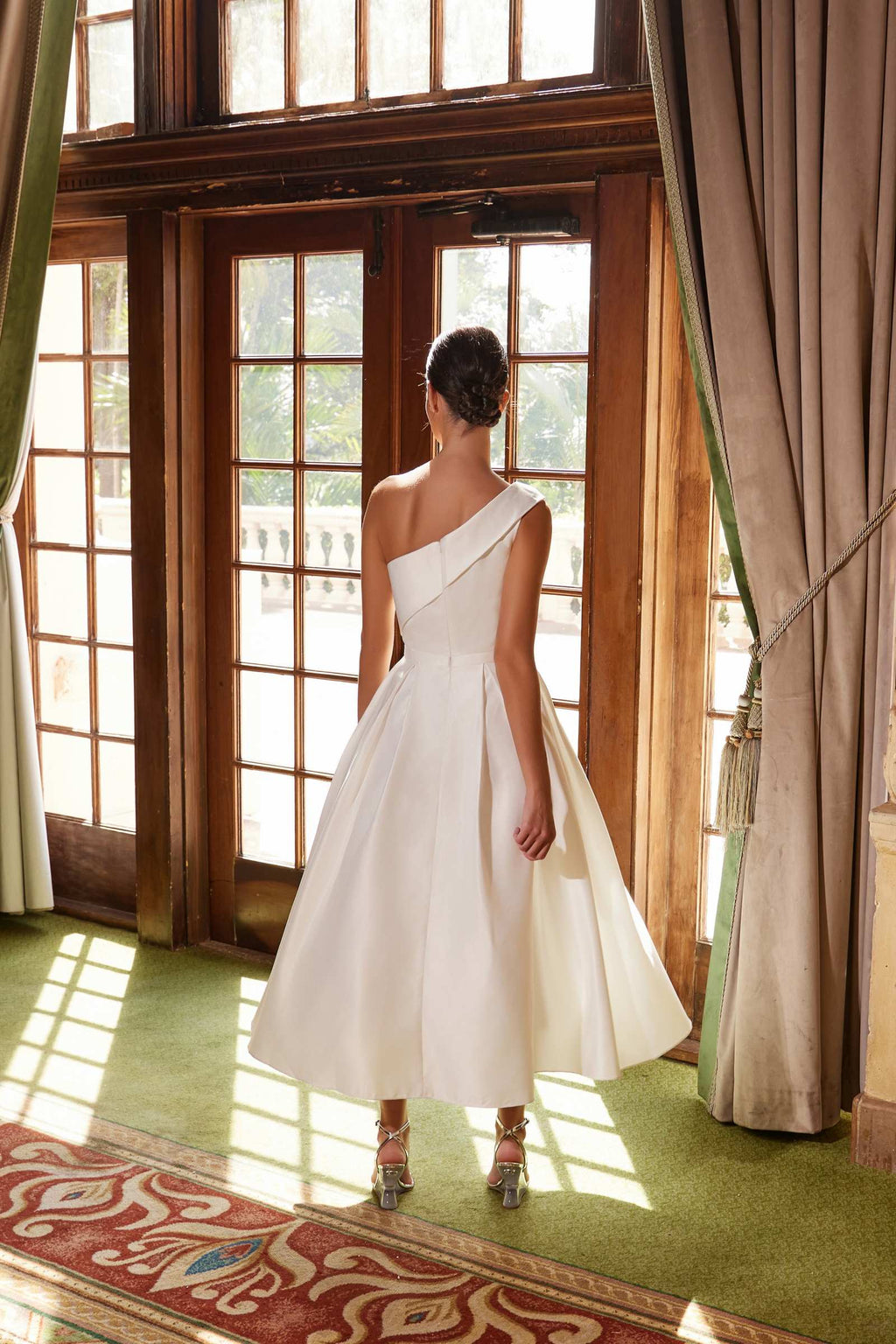 White one-shoulder satin tea-length gown from back, flared skirt and shaped waist