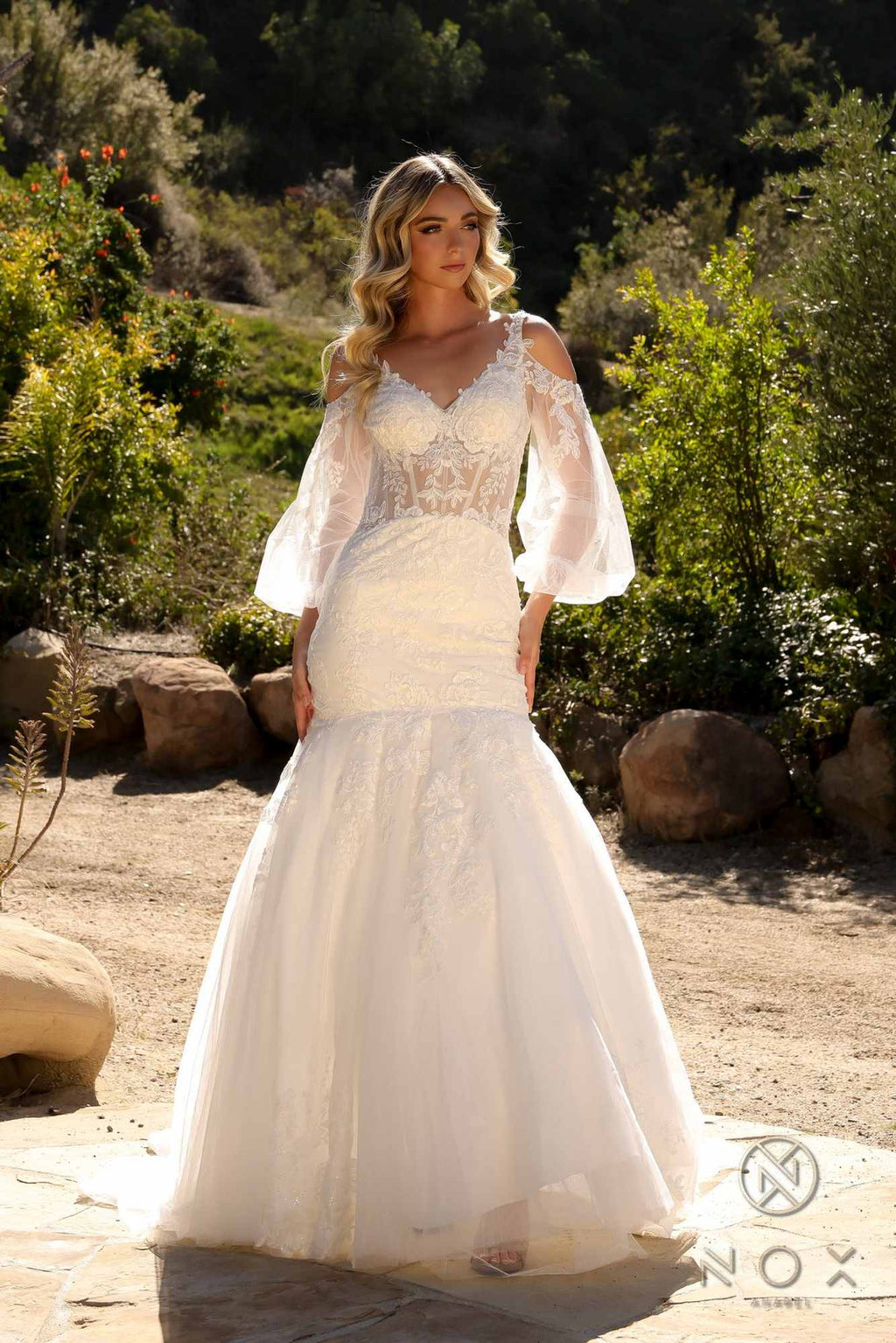 White lace mermaid bridal gown with fitted waist and long sheer bell sleeves