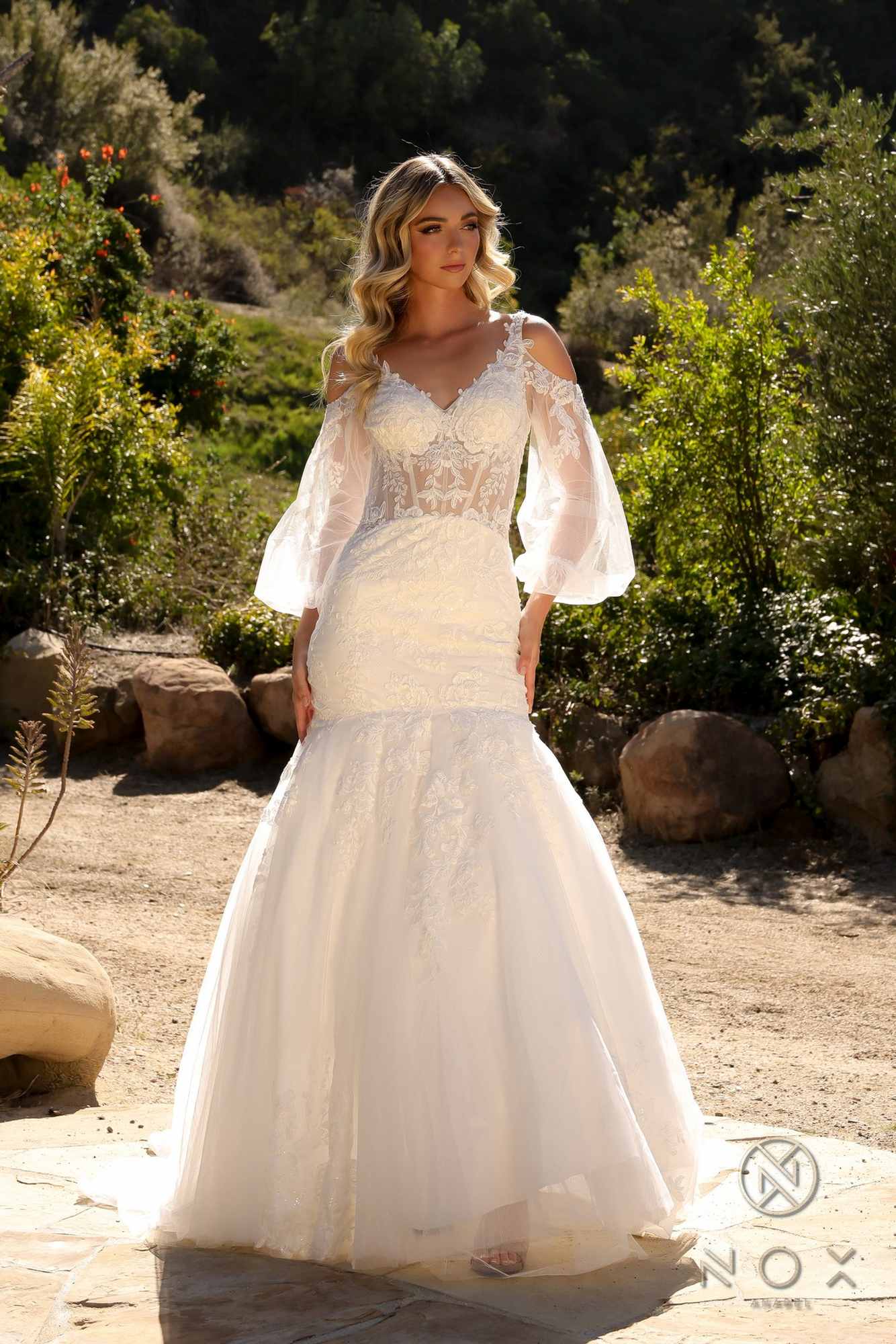 White lace mermaid bridal gown with fitted waist and long sheer bell sleeves