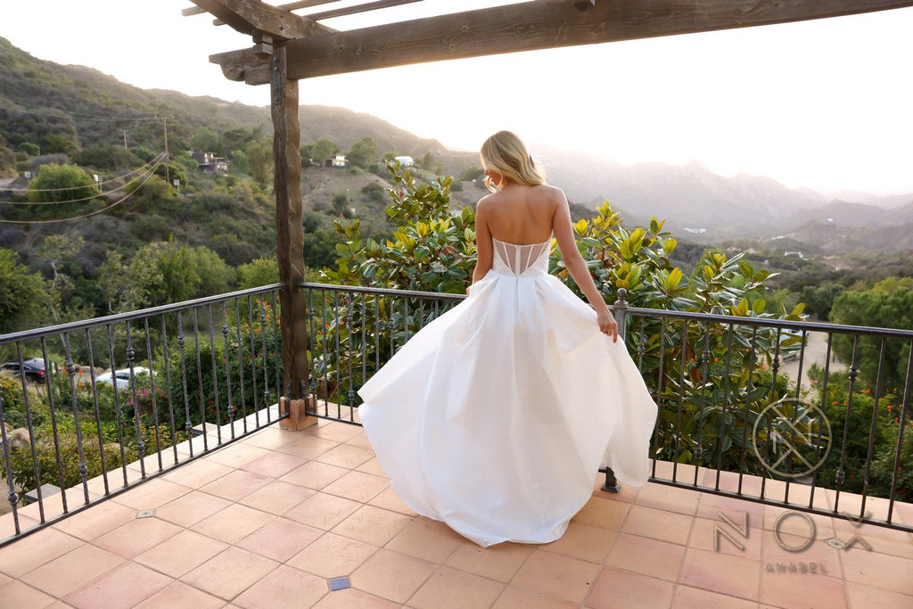 White strapless corset A-line wedding gown, back view with flowing skirt