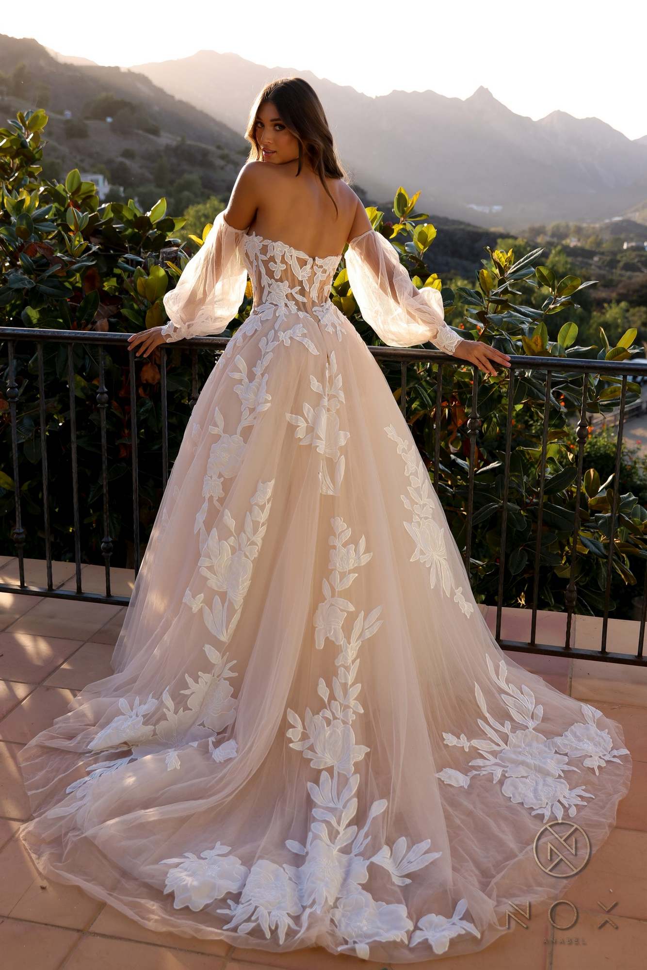 White A-line bridal gown with strapless bodice, long puff sleeves, and floral lace