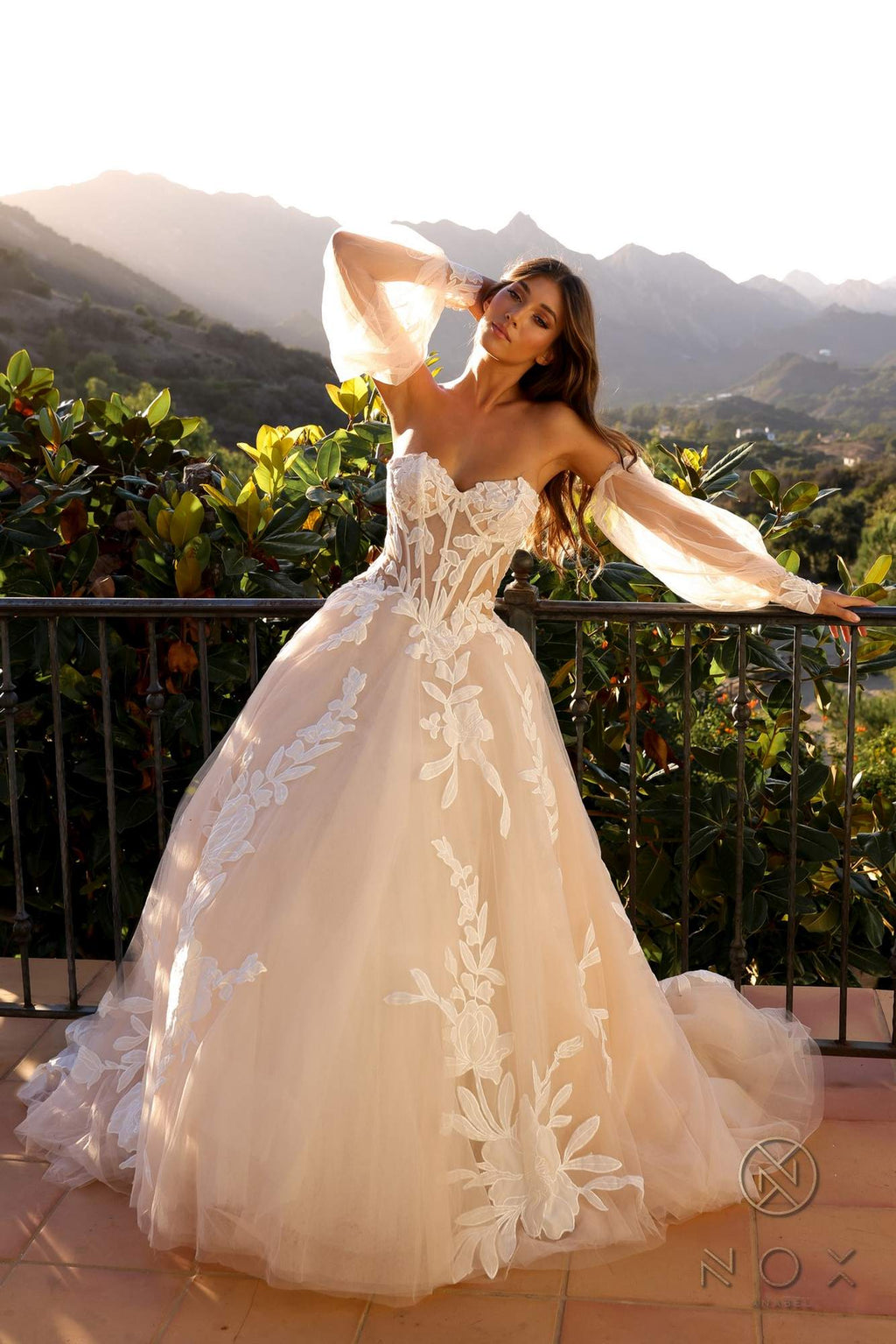 White strapless corset A-line bridal gown with long puff sleeves and cascading floral skirt