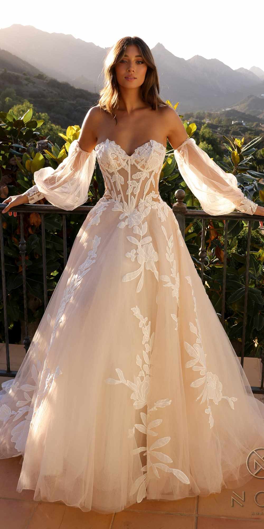 White strapless corset A-line bridal gown with long puff sleeves and floral appliqué