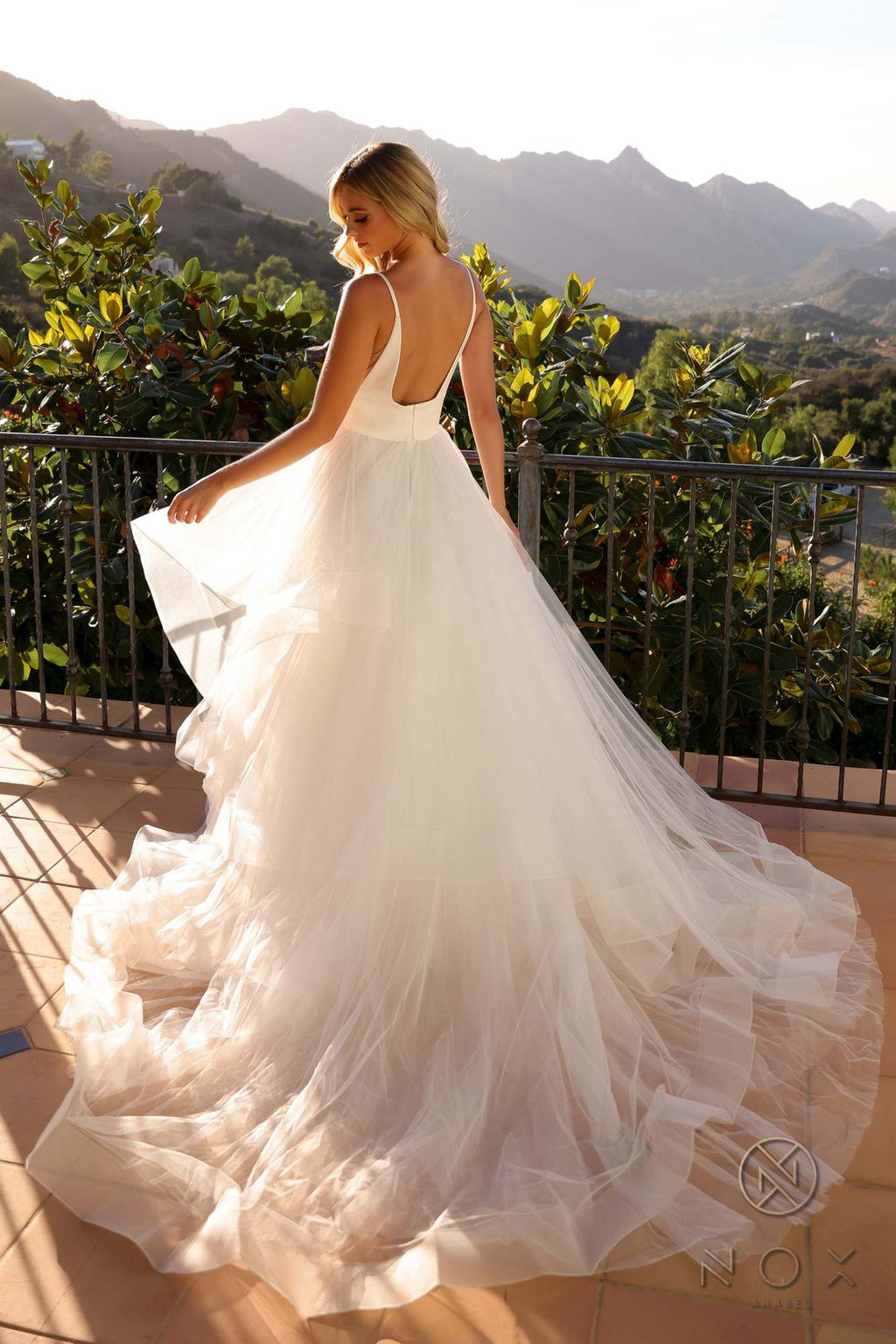 White sleeveless wedding gown, open-back V shape and layered A-line tulle skirt