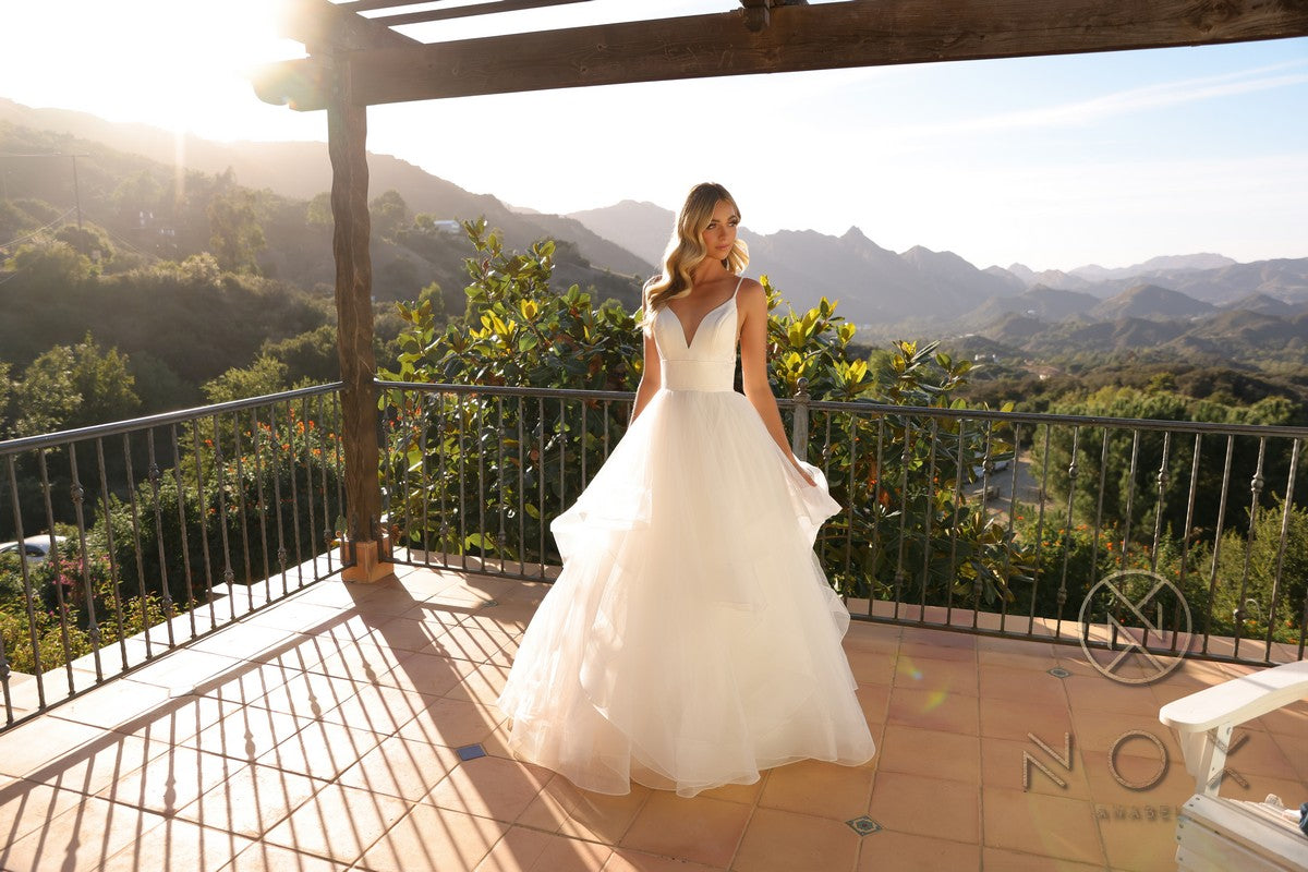White sleeveless A-line wedding gown with V-neck bodice and voluminous layered tulle skirt
