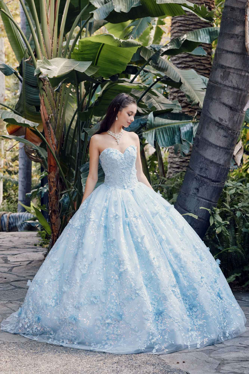 Light blue strapless sweetheart gown with full poofy skirt and sheer cape, side view