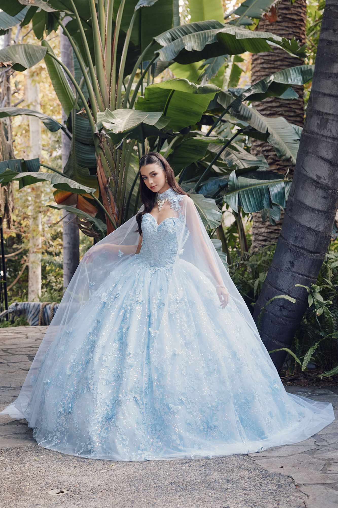 Light blue strapless sweetheart gown with cape, full poofy skirt, outdoor standing view