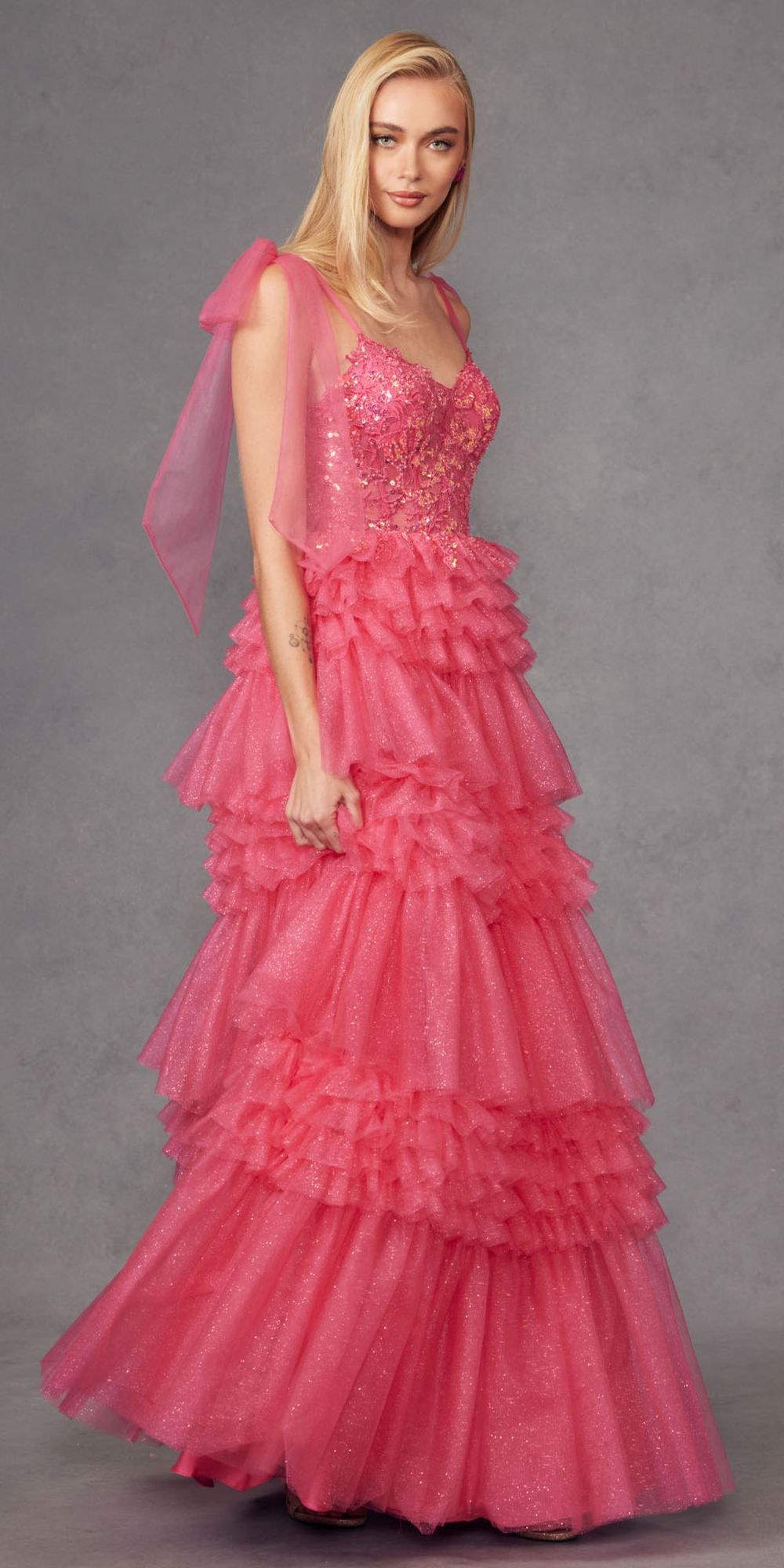 Fuchsia glitter tulle A-line gown with tiered ruffle skirt and draped bow sleeves