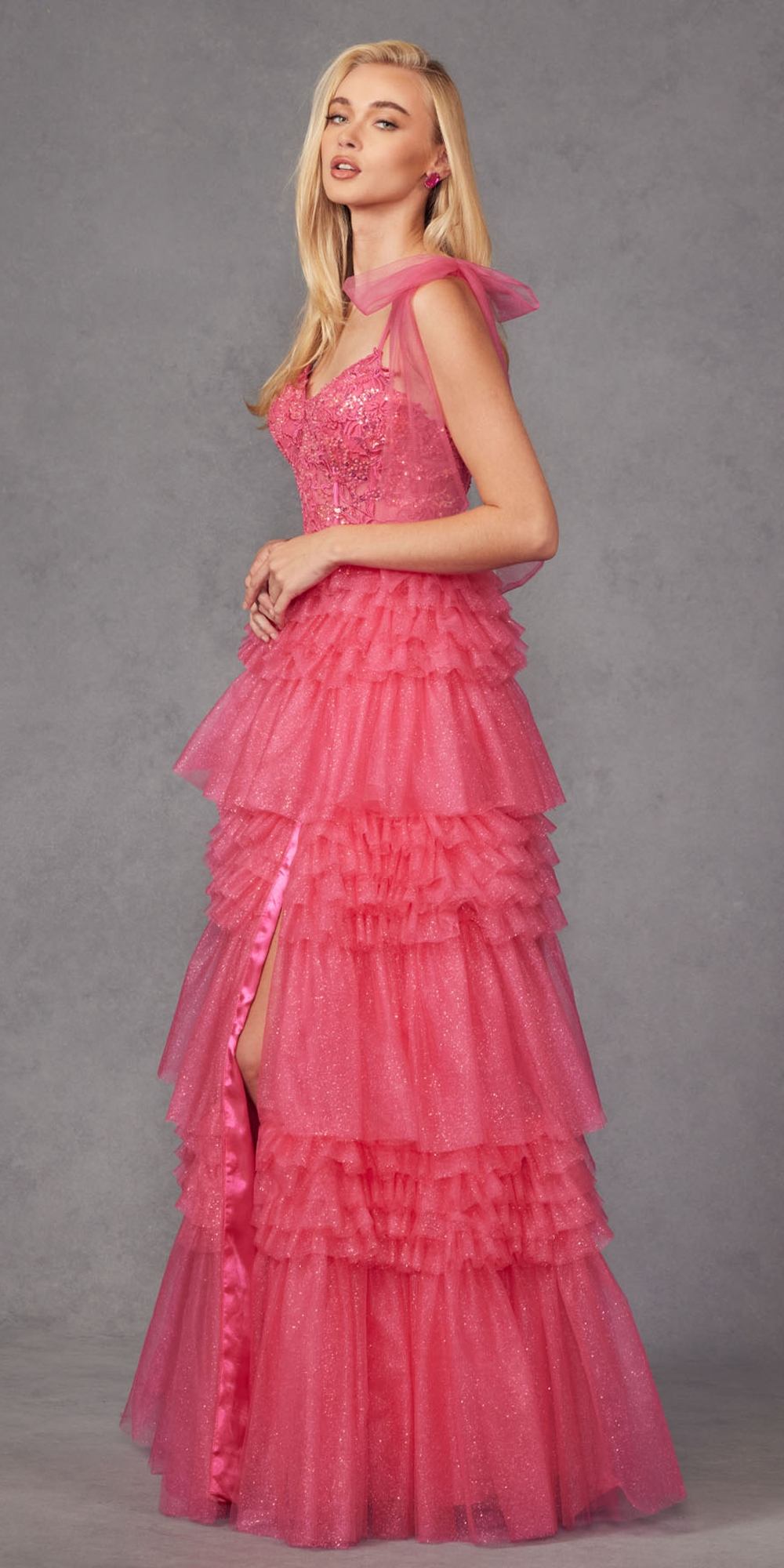 Fuchsia glitter tulle A-line gown with tiered ruffles, ribbon bow straps, leg slit