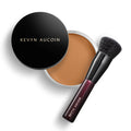 Foundation balm compact with round black lid, light tan balm, and makeup brush