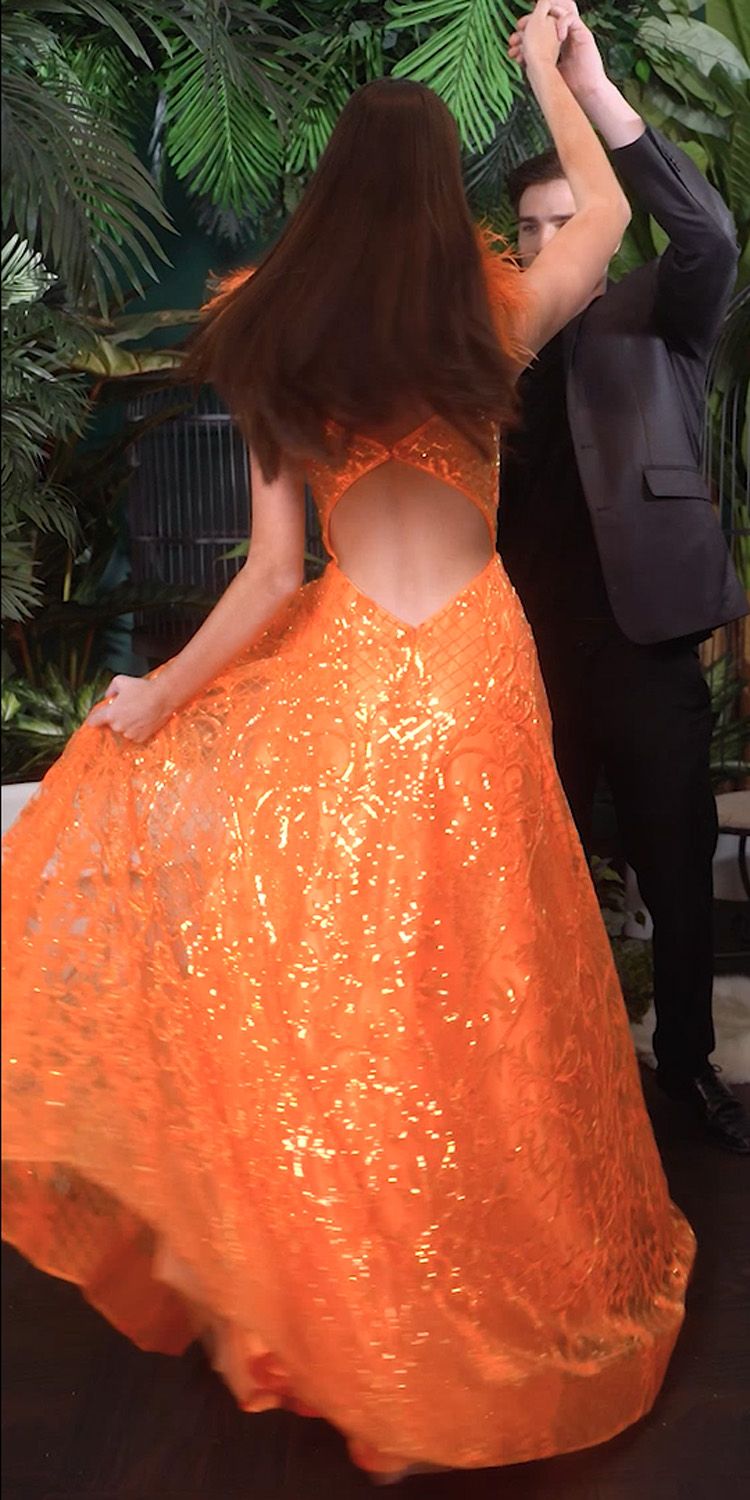 Neon orange sequin ball gown with feather back detail and full skirt