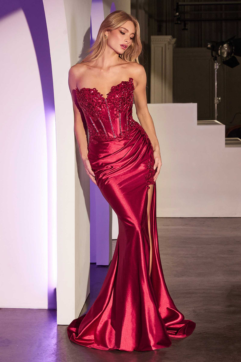 Red strapless fitted lace and satin gown with sweetheart neckline and side thigh slit.