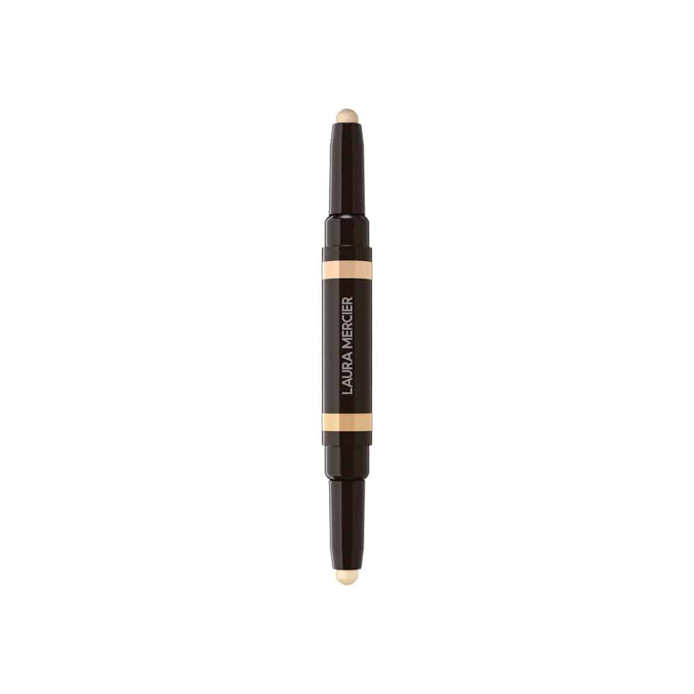 Concealer stick shown upright with dark body, orange center band, and beige tip