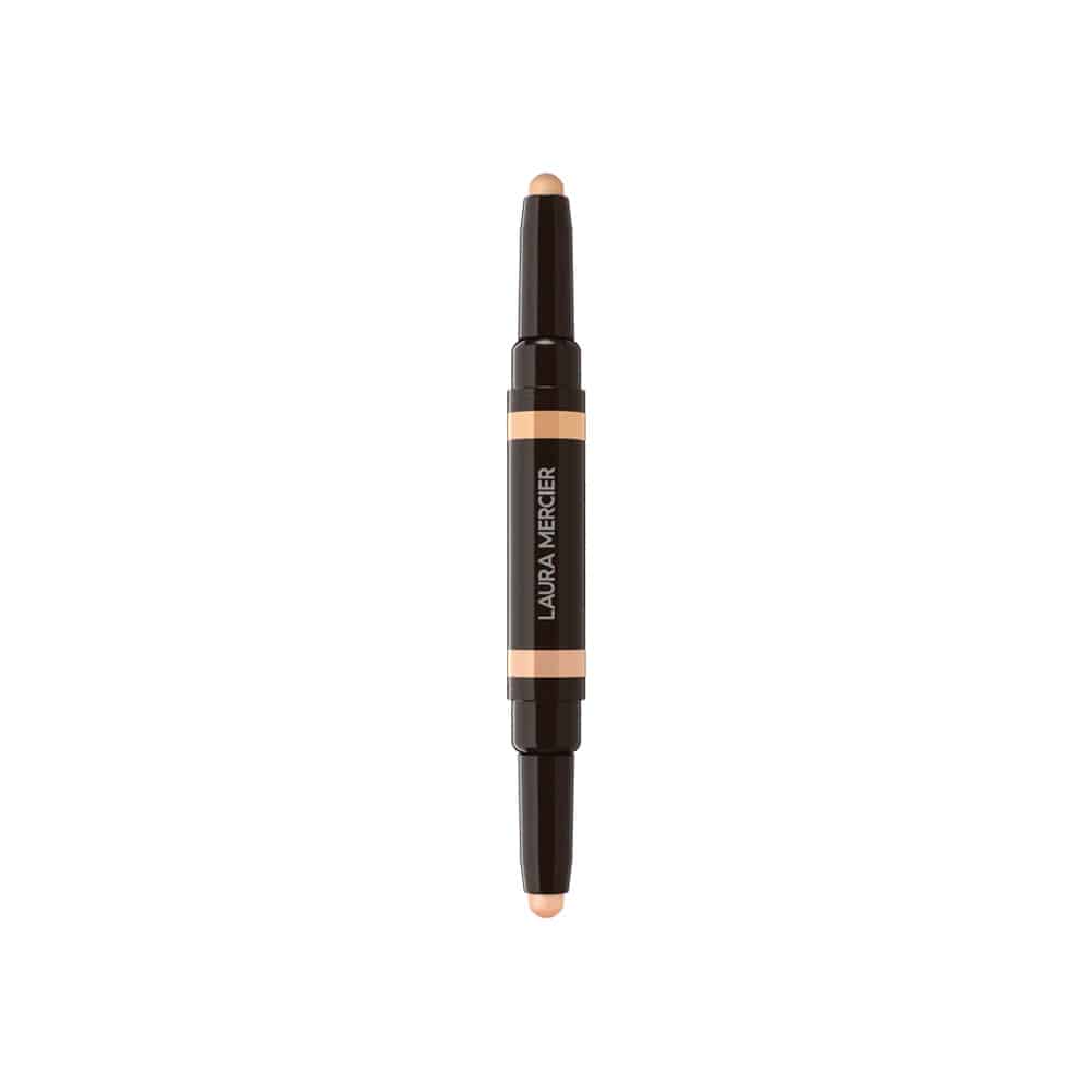 Concealer stick upright with dark packaging, orange band label, and beige tip