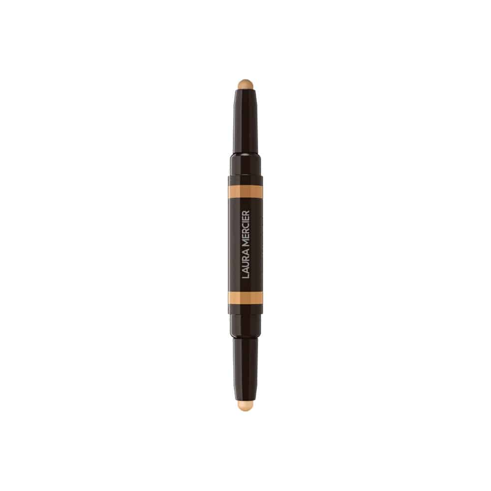 Concealer stick with dark case, orange label band, and beige product tip