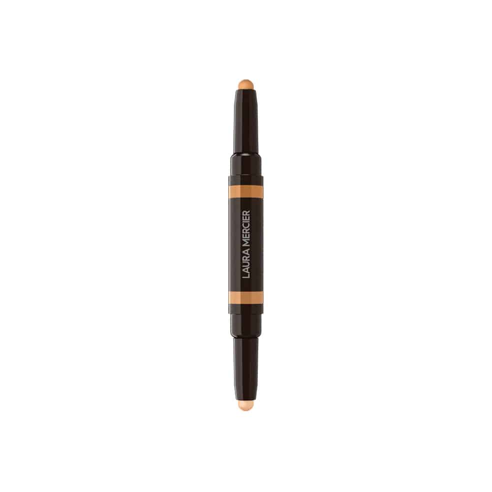 Concealer stick with beige applicator tip, dark barrel, and orange label band