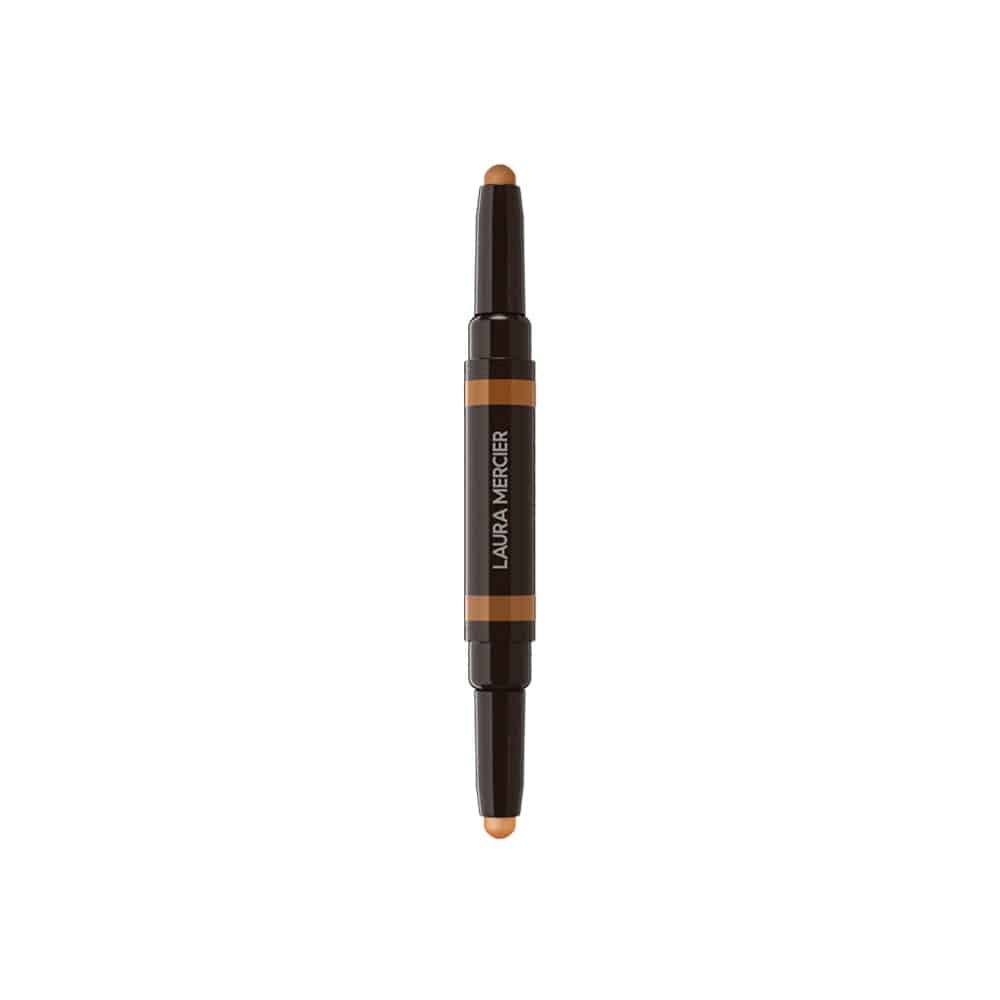 Concealer stick angled view showing beige tip and orange label on dark tube
