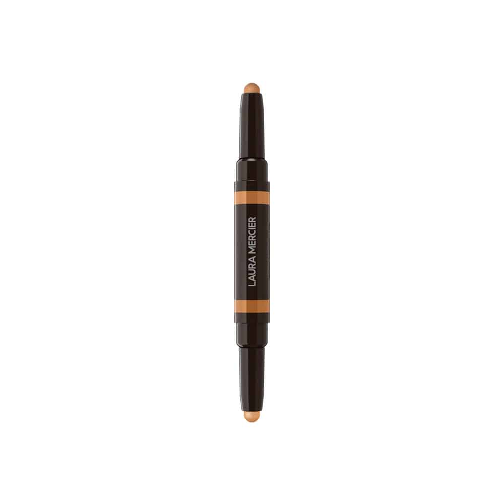 Concealer stick with beige tip, dark housing, and orange label stripe