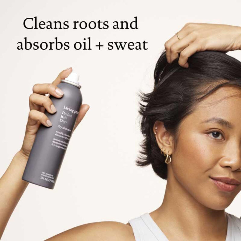 Dry shampoo aerosol bottle in hand, spray over dark hair roots