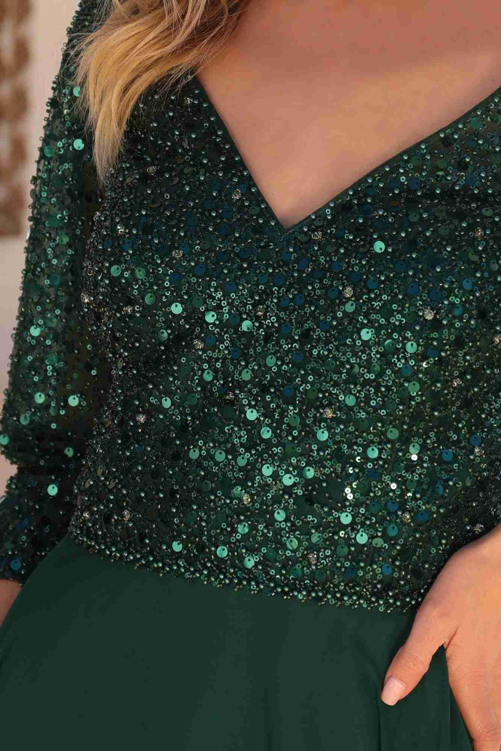 Embellished sequin bodice detail in emerald-green on dark green fabric