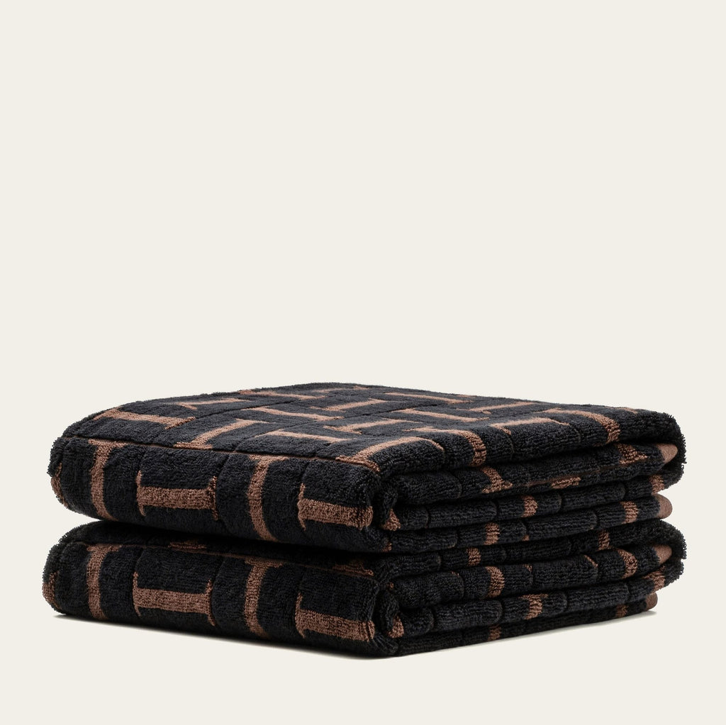 Folded cotton towel with tobacco-and-black geometric grid pattern