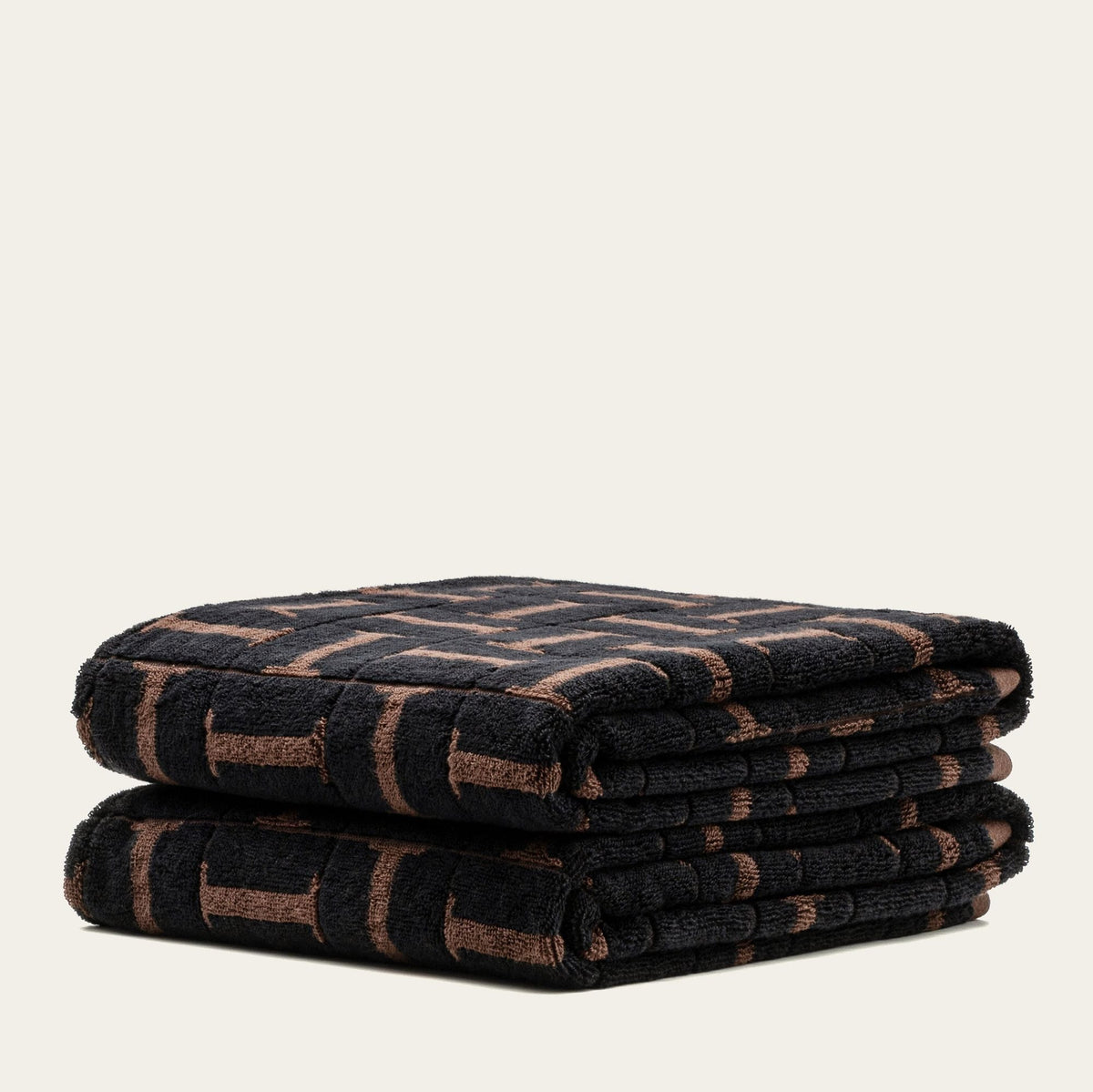 Folded cotton towel with tobacco-and-black geometric grid pattern