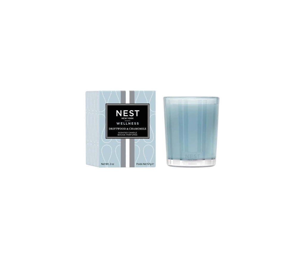 Scented candle set showing NEST Wellness box and pale blue glass jar, angled view