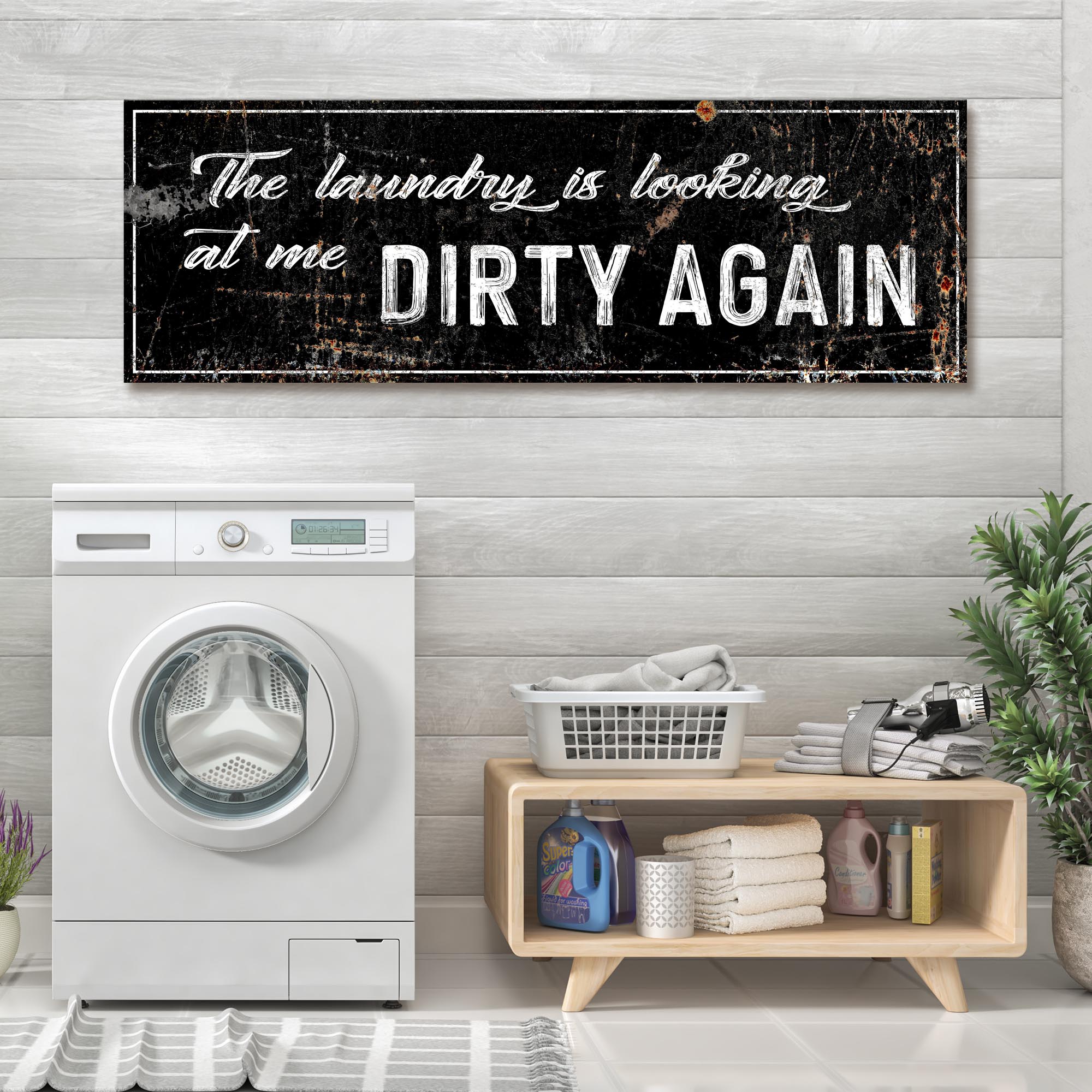 Rectangular laundry wall sign with black frame and distressed white text “DIRTY AGAIN”