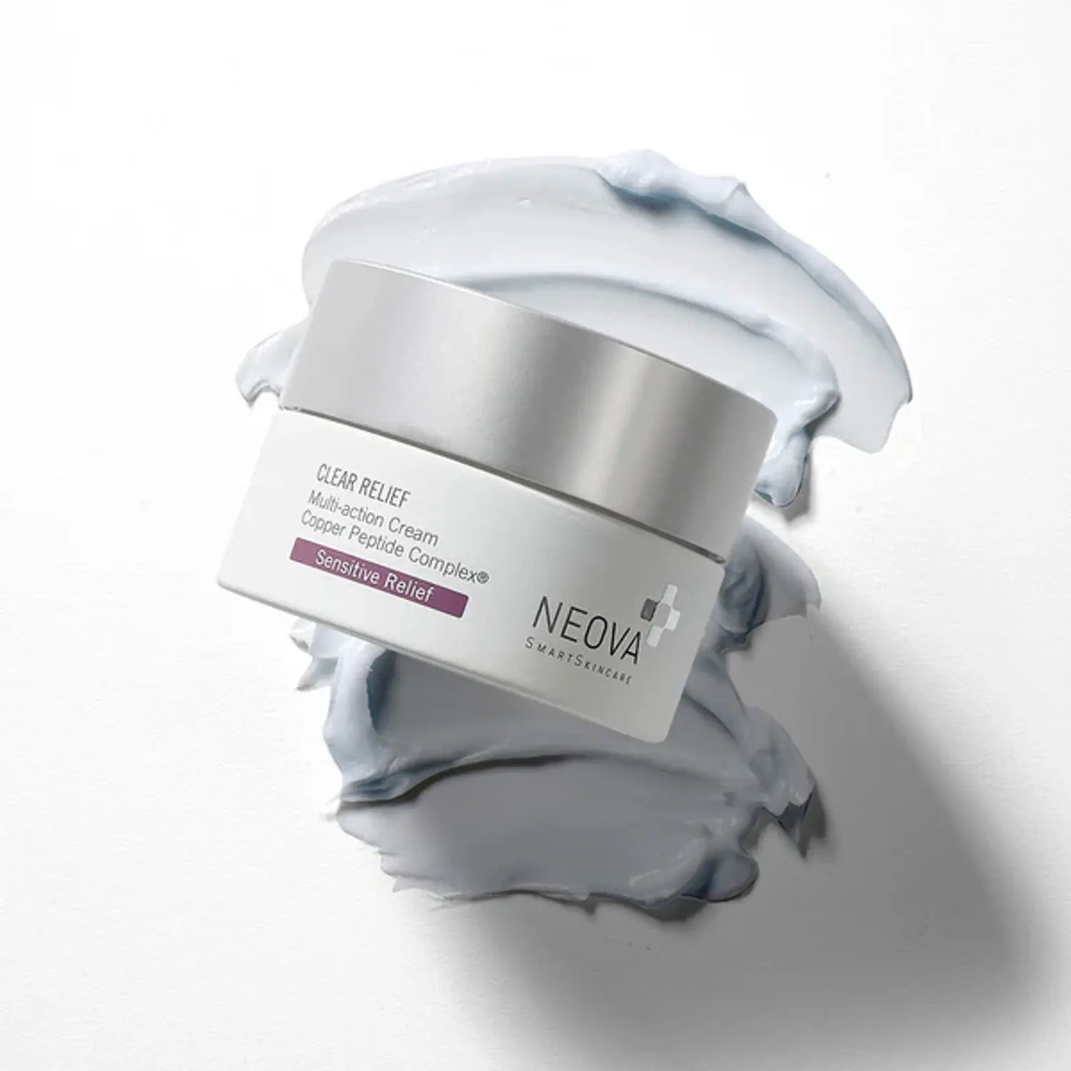 Neova Clear Relief cream jar with silver lid, surrounded by light blue cream smear