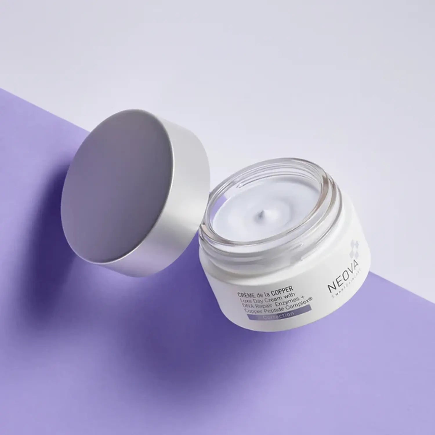 Open face cream jar with gray lid and pale blue cream