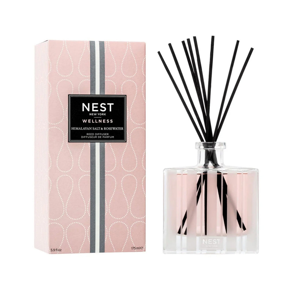 Glass diffuser bottle with pink liquid, black reeds, silver collar, NEST label