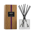 Glass reed diffuser with black reeds in faceted bottle, shown with Moroccan Amber box