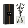 Reed diffuser set with clear glass bottle, black reeds, and NEST Sicilian Tangerine box