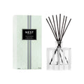 Reed diffuser set with clear glass bottle, black reeds, and Nest Indian Jasmine label